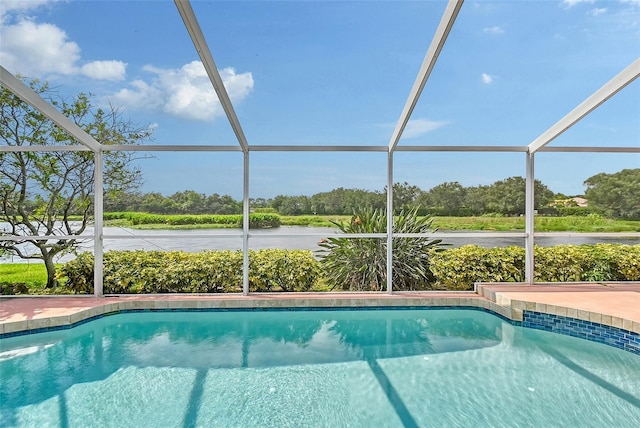 view of swimming pool featuring glass enclosure and a water view