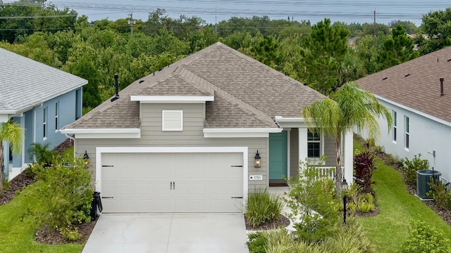 view of front of home featuring cooling unit and a garage