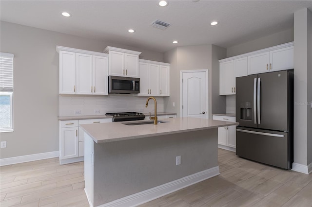 kitchen featuring a kitchen island with sink, sink, white cabinets, and stainless steel appliances