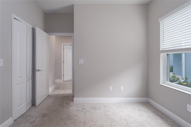 empty room featuring a healthy amount of sunlight and light carpet