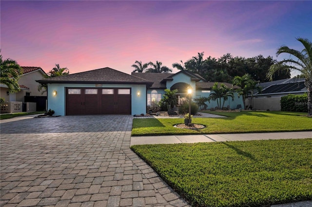 view of front facade with a garage and a yard