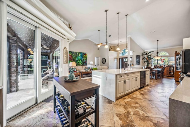 kitchen featuring pendant lighting, an island with sink, lofted ceiling, stainless steel fridge, and ceiling fan with notable chandelier