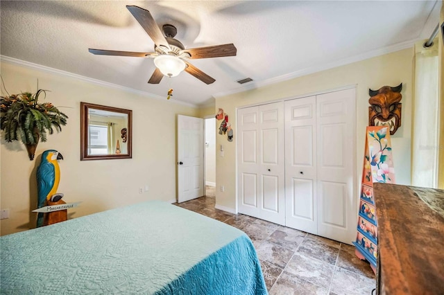 bedroom with ornamental molding, a closet, ceiling fan, and a textured ceiling