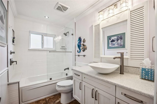 full bathroom with vanity, a textured ceiling, crown molding, toilet, and tiled shower / bath