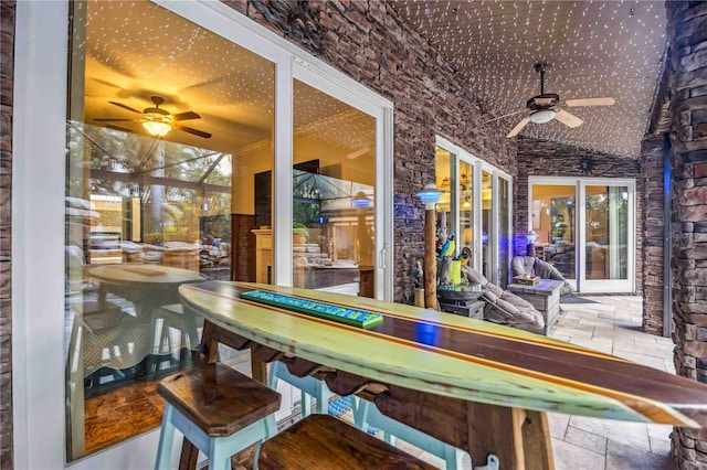 interior space with ceiling fan and stone tile flooring