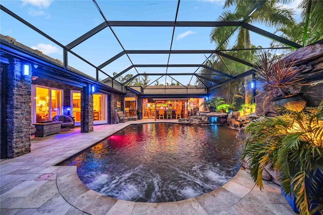 view of pool with glass enclosure and a patio area