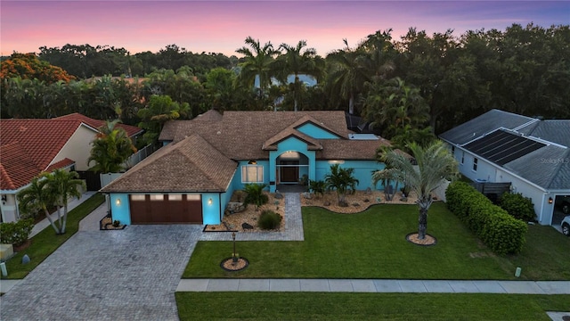 view of front of home with a lawn and a garage