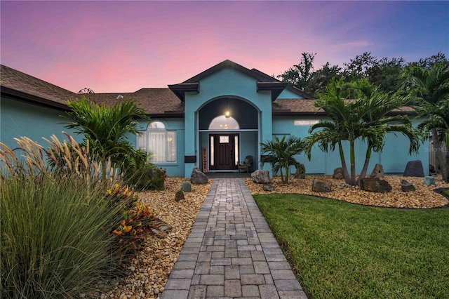 view of front of property with a yard and stucco siding