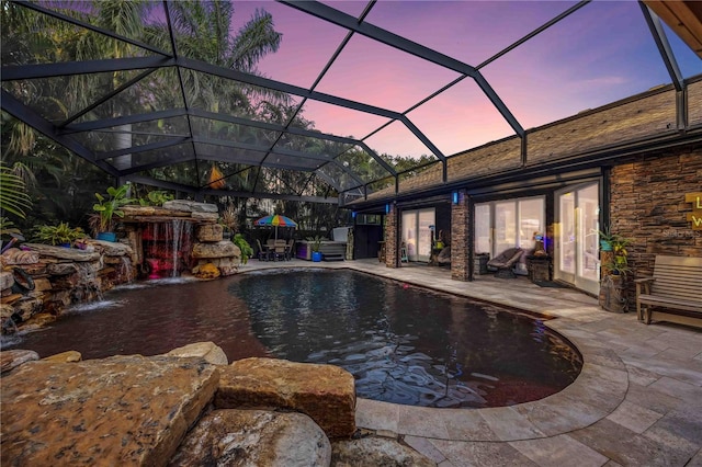 pool at dusk with a patio, a lanai, and an outdoor pool