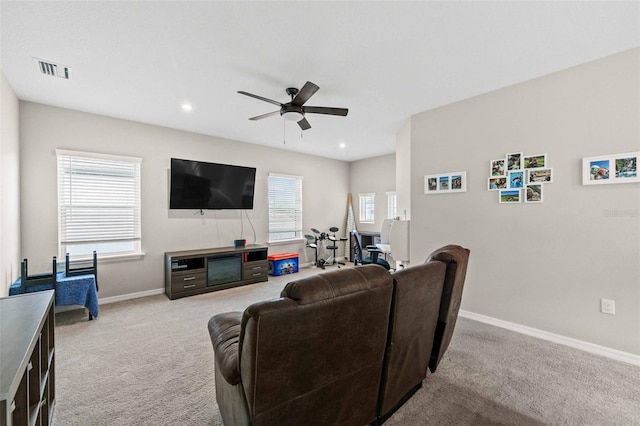 carpeted living room with ceiling fan