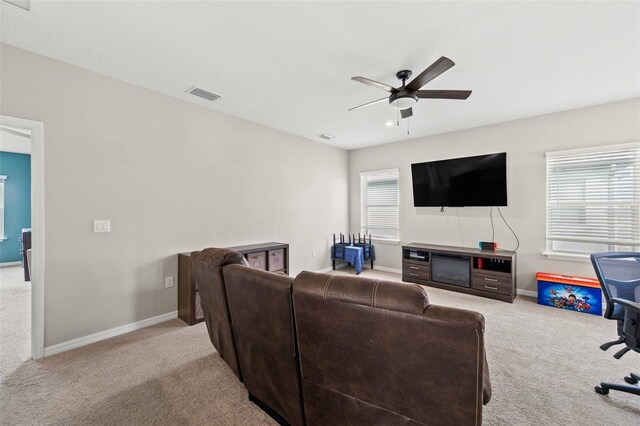 living room with ceiling fan, light colored carpet, and a wealth of natural light