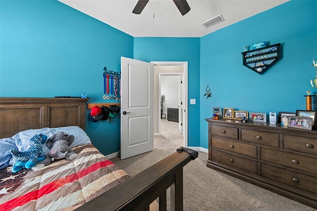 bedroom featuring ceiling fan, a textured ceiling, and light colored carpet