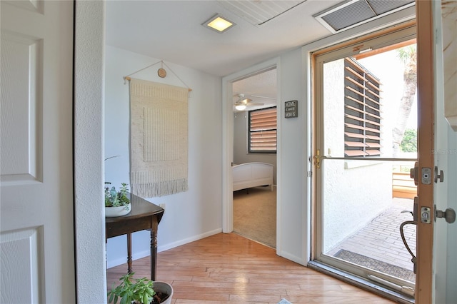 doorway featuring ceiling fan, a healthy amount of sunlight, and light hardwood / wood-style floors