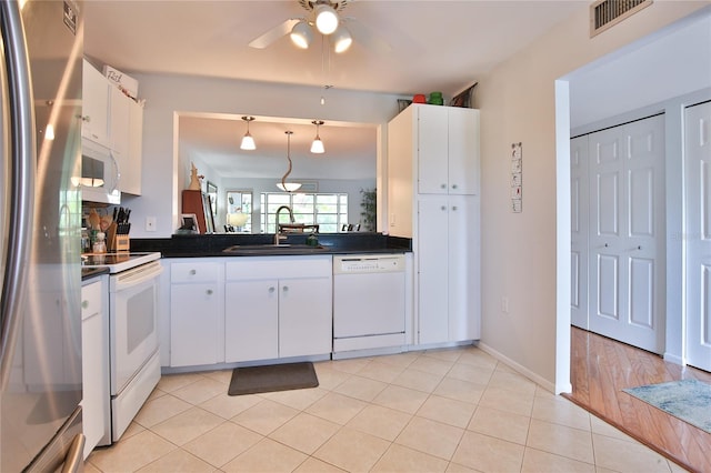 kitchen with light hardwood / wood-style flooring, white cabinets, pendant lighting, white appliances, and sink