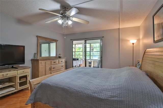 bedroom with ceiling fan, a textured ceiling, and hardwood / wood-style flooring