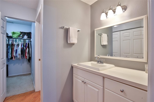 bathroom with a textured ceiling, vanity, and hardwood / wood-style flooring