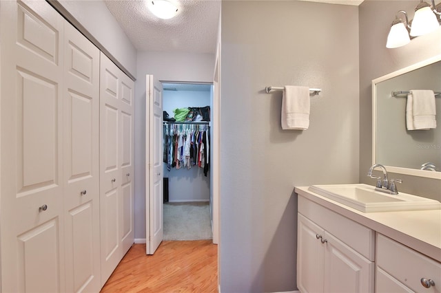 bathroom with vanity, a textured ceiling, and hardwood / wood-style floors