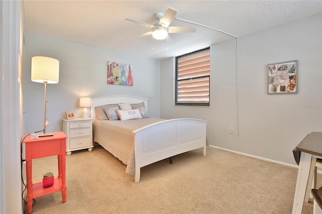 bedroom featuring ceiling fan, a textured ceiling, and light carpet