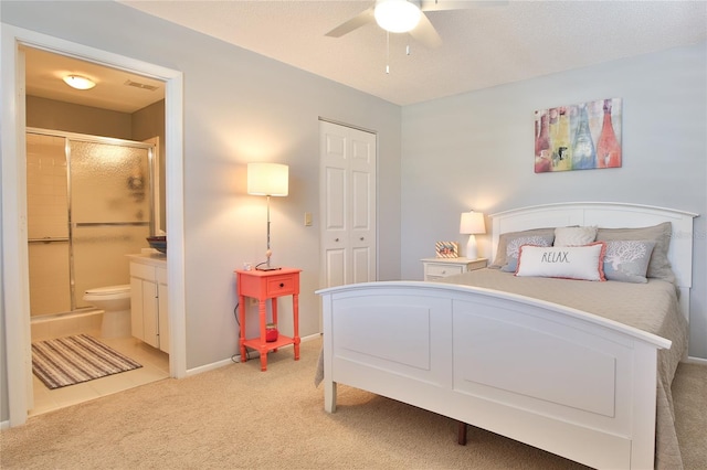 carpeted bedroom with connected bathroom, a closet, and ceiling fan