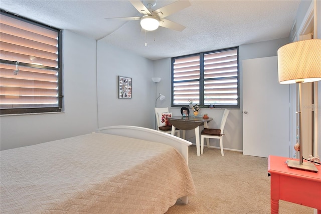 bedroom featuring ceiling fan, a textured ceiling, and carpet floors