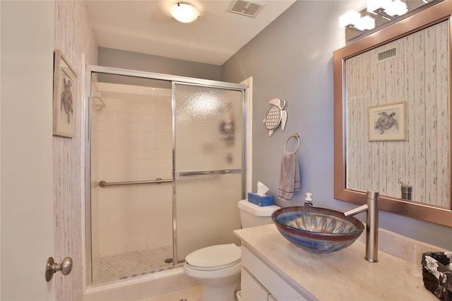 bathroom featuring tile patterned floors, vanity, a shower with door, and toilet