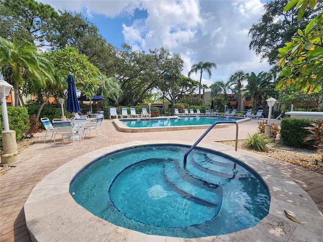 view of swimming pool featuring a community hot tub and a patio