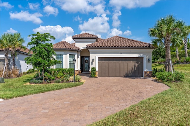 mediterranean / spanish-style home featuring a front yard and a garage