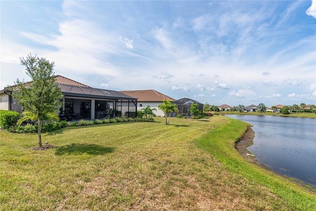 view of yard with a lanai and a water view