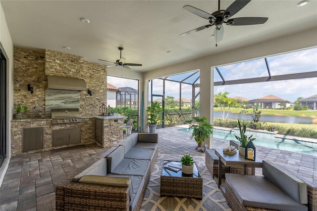 view of patio with outdoor lounge area, exterior kitchen, a lanai, grilling area, and a water view