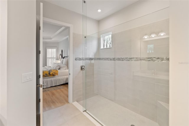 bathroom featuring tiled shower, hardwood / wood-style floors, and ornamental molding