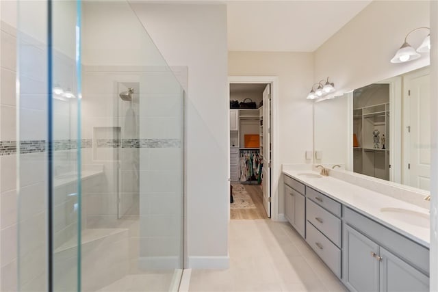 bathroom featuring tile patterned flooring, vanity, and tiled shower