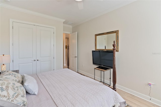 bedroom featuring light wood-type flooring, a closet, ornamental molding, and ceiling fan