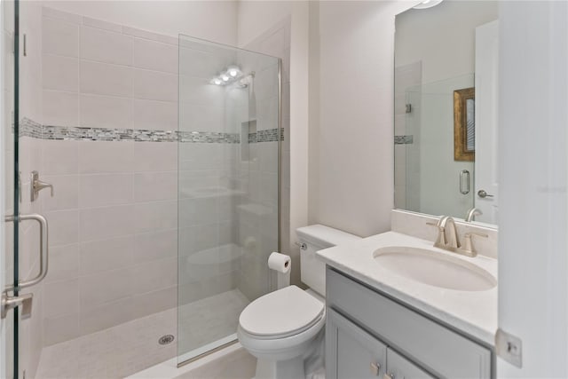 bathroom featuring vanity, an enclosed shower, and toilet