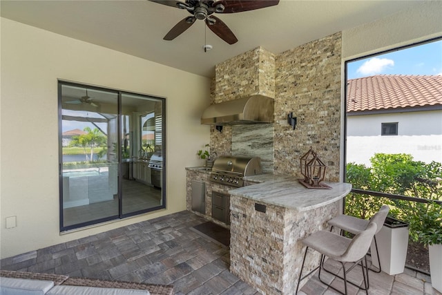 view of patio / terrace featuring grilling area, ceiling fan, and exterior kitchen