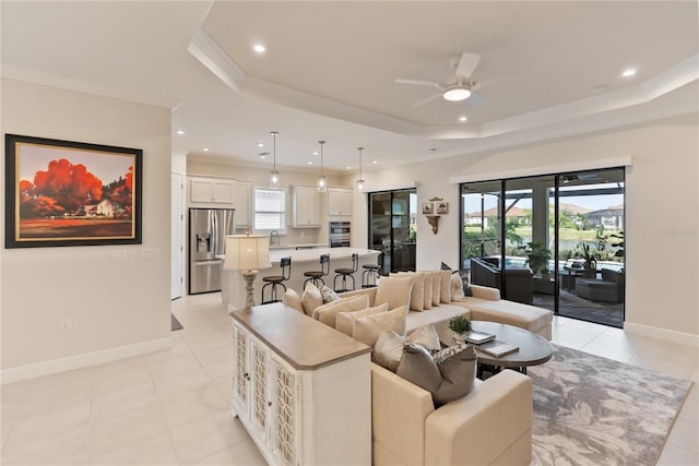 living room featuring a raised ceiling, sink, crown molding, ceiling fan, and light tile patterned floors