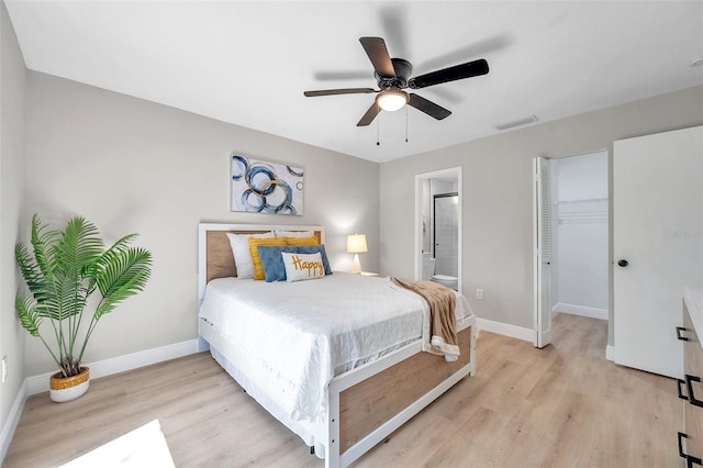 bedroom featuring light wood-type flooring, a closet, ceiling fan, and ensuite bathroom