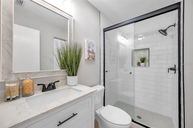 bathroom with walk in shower, toilet, and vanity