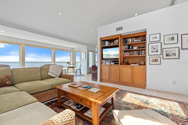 living area with lofted ceiling, visible vents, and recessed lighting