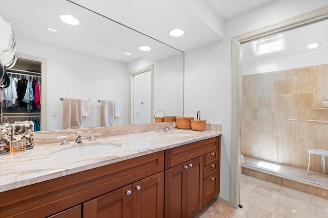 full bathroom featuring a tile shower, double vanity, a sink, and recessed lighting