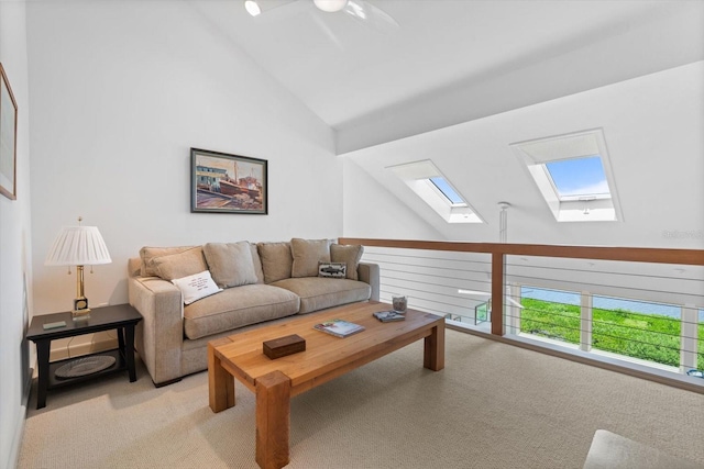 living room featuring a skylight, ceiling fan, high vaulted ceiling, and light colored carpet