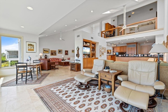 living room featuring a skylight, visible vents, a ceiling fan, high vaulted ceiling, and recessed lighting