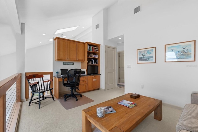 office featuring high vaulted ceiling, a skylight, and light carpet