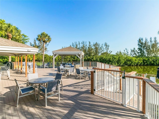 wooden deck with outdoor dining area and a gazebo