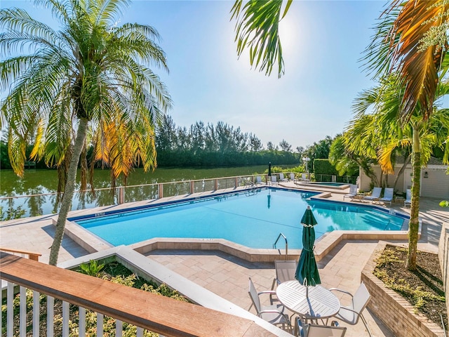 view of pool featuring a patio and a water view