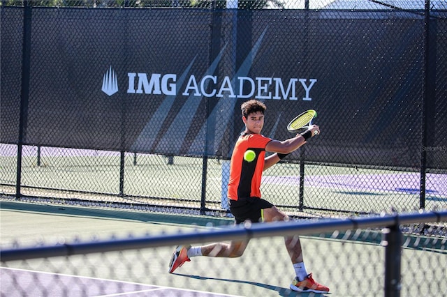 view of tennis court featuring fence