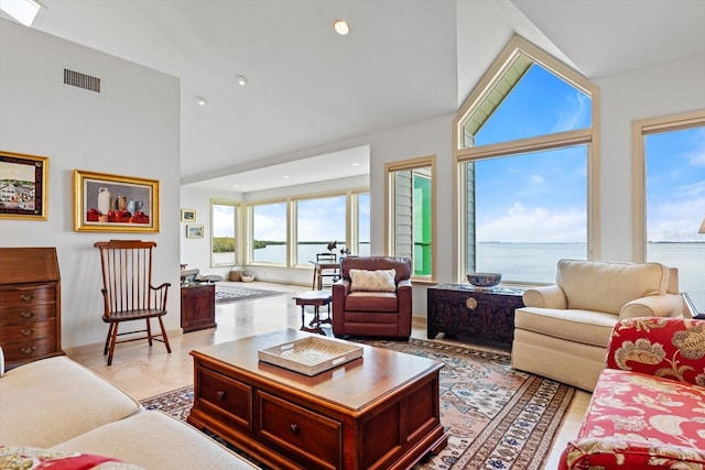 living room with high vaulted ceiling and a water view