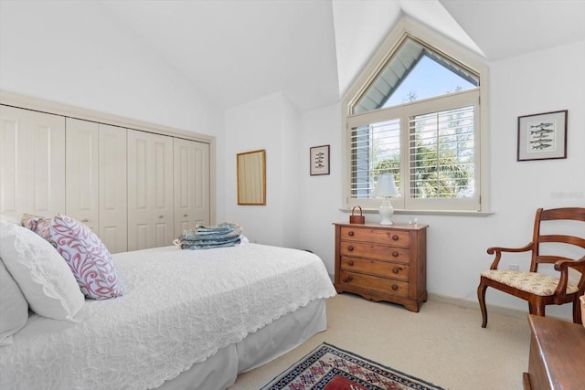 bedroom with carpet, lofted ceiling, and a closet