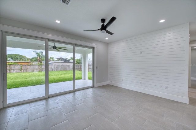 tiled empty room featuring ceiling fan