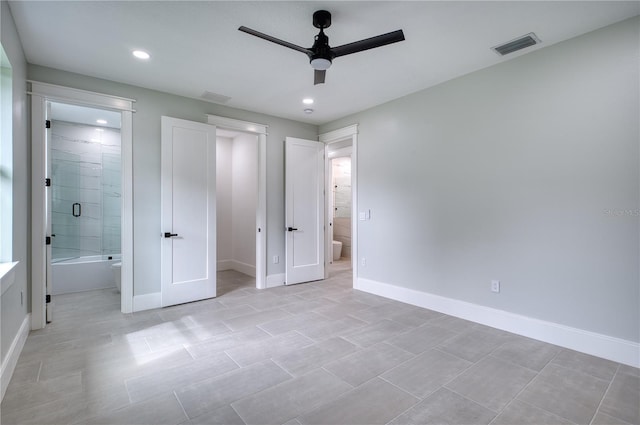 unfurnished bedroom featuring ensuite bath, light tile patterned flooring, and ceiling fan