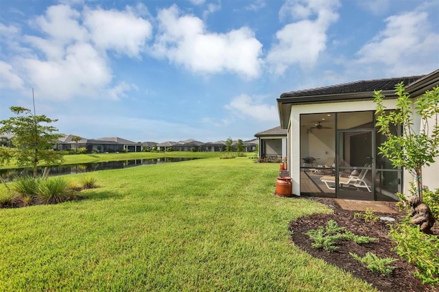 view of yard with a sunroom and ceiling fan